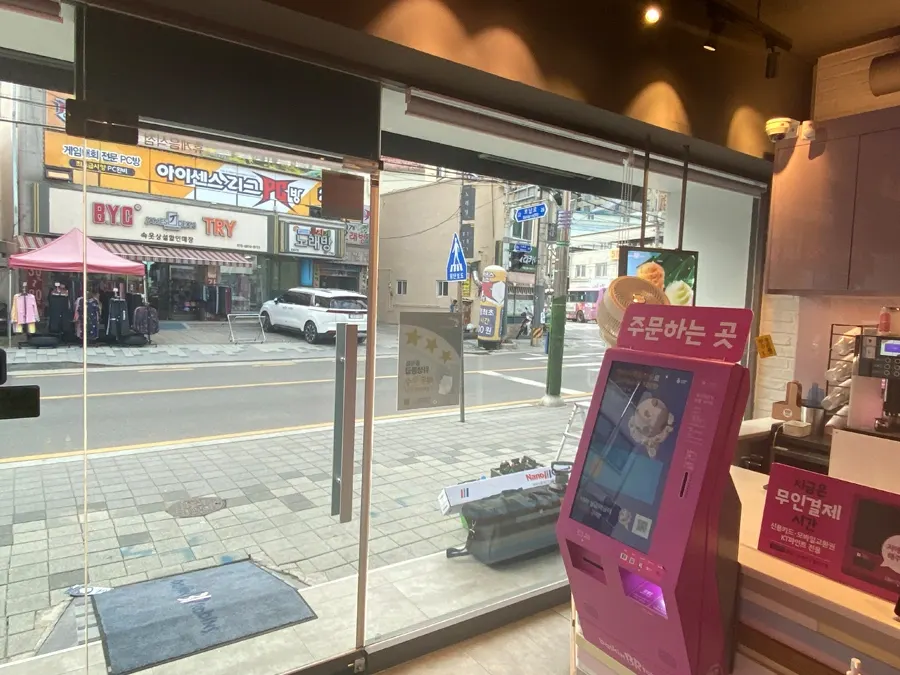매장 키오스크와 통유리가 맞닿은 구간 클로즈업 사진