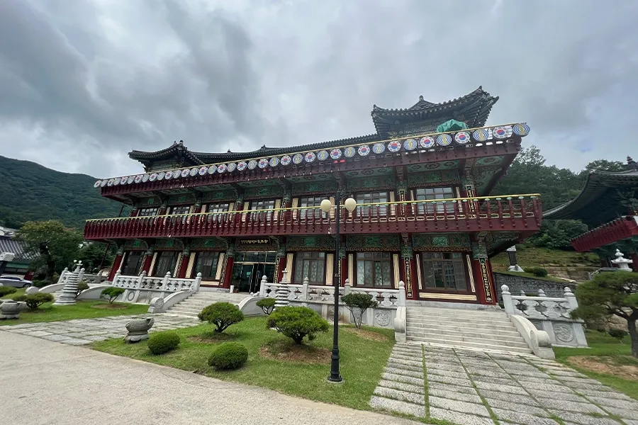 처마와 난간이 화려한 전통 양식의 2층 건물 외관 사진