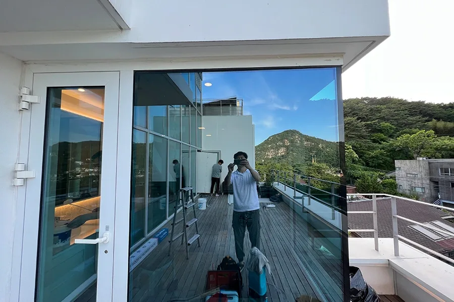 옥상 테라스에서 촬영한 산과 마을 전망 통유리 사진
