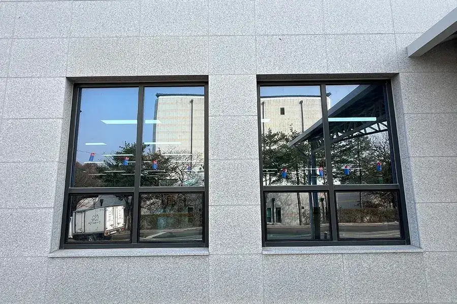석재 외벽에 설치된 창 두 개를 가까이서 찍은 사진