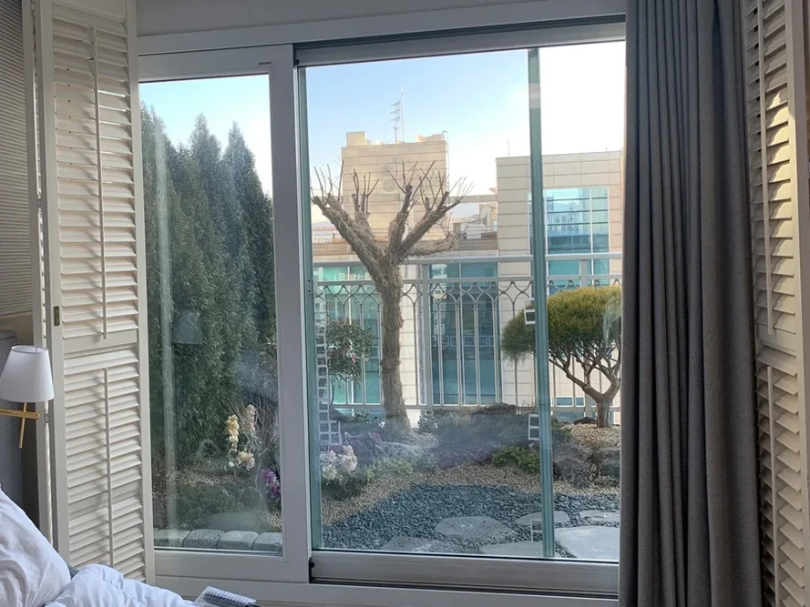 정원이 보이는 침실 창가 풍경 사진